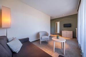 ein Wohnzimmer mit einem Sofa und einem Tisch in der Unterkunft Hotel Frangart an der Weinstraße in Appiano sulla Strada del Vino