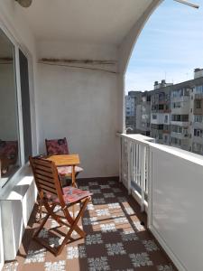 een stoel op een balkon met een raam bij Lefterov's Guests Suite in Varna