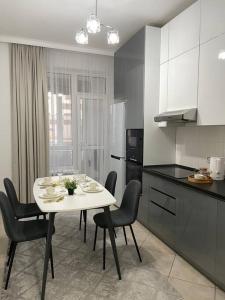 a kitchen with a table and chairs in a room at Жк Expo residents in Taldykolʼ