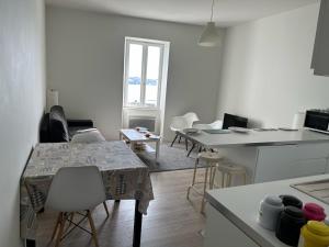 - une cuisine avec une table et des chaises dans la chambre dans l'établissement Appartement Design III - Port du Rosmeur - Douarnenez, à Douarnenez