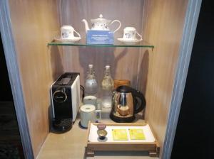 a kitchen with a coffee maker and a toaster on a shelf at Sojourn Guest House Melaka in Malacca