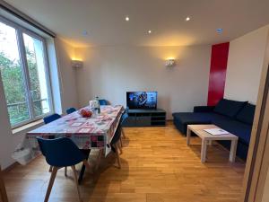 ein Wohnzimmer mit einem Tisch und einem Sofa in der Unterkunft Maison Climatisée 04 chambres Paris Disney CDG in Gagny