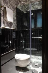 a bathroom with a glass shower and a toilet at The Saga Hotel in New Delhi