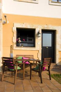 un tavolo e sedie in legno con una televisione appesa a un muro di Apartamentos Santillana del Mar a Santillana del Mar