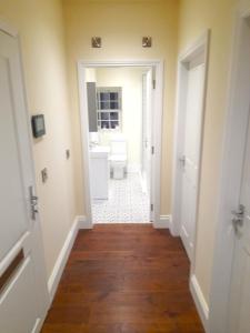 a hallway of a bathroom with a toilet and a sink at Kirkcudbright Holiday Apartments - Apartment E in Kirkcudbright