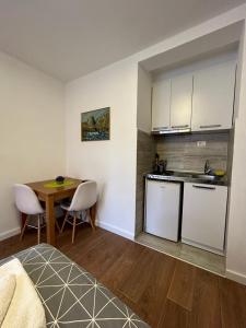 a kitchen with a table and a kitchen with a table and chairs at Apartmani Perovic in Bar