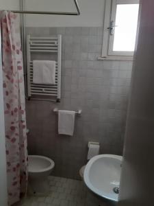 a white bathroom with a sink and a toilet at Hotel Migani in Rimini