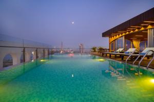 a large swimming pool with chairs on a building at Gold Plaza Hotel - Located just 100m from the Walking Street in Danang