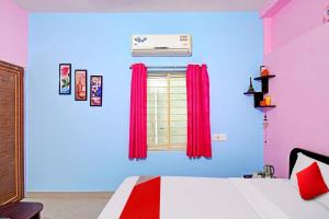 a bedroom with a bed and a window with red curtains at Flagship Ananta Palace in Bhubaneshwar