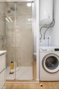uma casa de banho com um chuveiro e uma máquina de lavar roupa em Azahar Metropol Parasol, Medium-sized Parking gifted for free em Sevilha