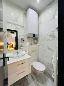 a white bathroom with a toilet and a sink at 160 - Urban Fashion Week Paris Vuitton in Paris