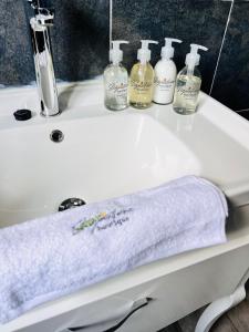 a white sink with a towel and bottles on it at Signature Boutique Guesthouse in Maun