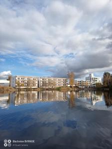 einen Blick auf die Apartmentgebäude über einen Wasserkörper in der Unterkunft Seehotel Forst in Forst