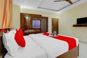 a bedroom with a large white bed with red pillows at Flagship Hotel Starwood in Jammu