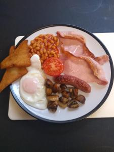 talerz jedzenia śniadaniowego z jajkami, fasolką bekonu i tostem w obiekcie Tirionfa Guest House w mieście Criccieth