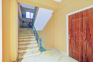 a stairway with a wooden door and a staircase at Townhouse OAK Hi-City in Kamakhya