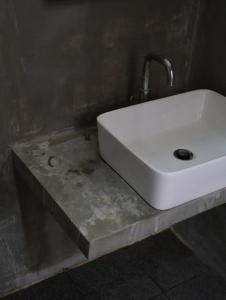 een witte wastafel op een betonnen aanrecht in een badkamer bij BLANK GUEST HOUSE in Siem Reap