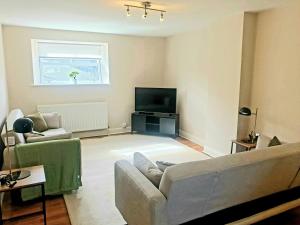 a living room with a couch and a tv at Freedom Hall Apartment in Queensbury