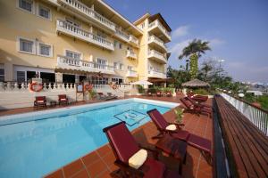 a swimming pool with chairs and a hotel at Victoria Chau Doc Hotel in Chau Doc