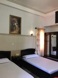 Habitación de hotel con 2 camas y espejo en KHÁCH SẠN HỒNG KÔNG, en Buon Ma Thuot