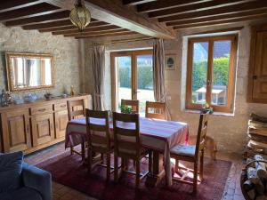 a dining room with a table and chairs and a dog at La Petite Breuille in Lainsecq