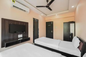 sypialnia z 2 łóżkami i telewizorem z płaskim ekranem w obiekcie OYO The Orchid w mieście Jamshedpur