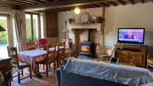 a living room with a couch and a fireplace at La Petite Breuille in Lainsecq