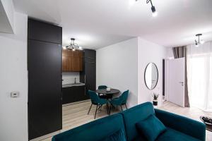 - un salon avec un canapé bleu et une table dans l'établissement City Center Accomodation- 401, à Reşiţa