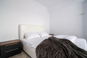 - une chambre avec un lit blanc et une table de nuit dans l'établissement City Center Accomodation- 401, à Reşiţa