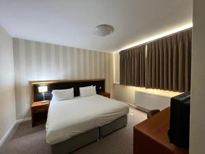 um quarto de hotel com uma cama e uma televisão em Brook Mollington Banastre Hotel & Spa em Chester