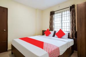 a bedroom with a large bed with red pillows at Hotel O Anu Grand in Visakhapatnam