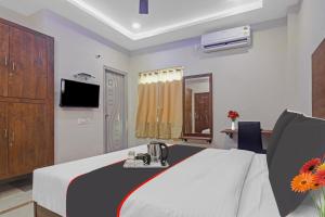 een hotelkamer met een bed en een televisie bij Srinika Inn in Hyderabad