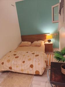 パリにあるHome Cosy ARENA Porte de la Chapelleのベッドルーム1室(ベッド1台、ランプ付きテーブル付)