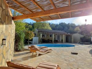 um pátio com espreguiçadeiras e uma piscina em Villa Stefania em Ágios Ioánnis