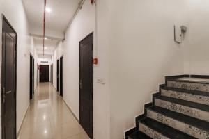 a hallway with stairs and a black door at Insight Inn Near Gomti Riverfront Park in Vibhuti Khand