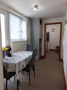 a dining room with a table and chairs and a window at The Barn - Cosy cottage with Countryside views in Ludchurch