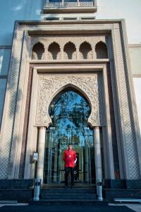 um homem parado num arco num edifício em Heritage Luxury Suites All Suite Hotel em Lahore