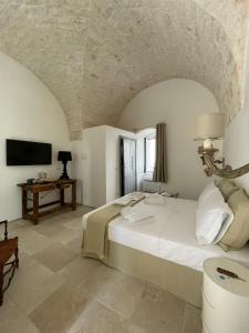 1 dormitorio con 1 cama grande y TV en Nobile Dimora di Puglia, en Ostuni