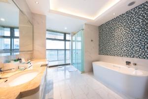 a bathroom with a tub and a sink and a bath tub at Wuhu Suning Universal Hotel in Wuhu