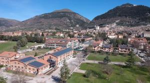 een luchtzicht op een campus met bergen op de achtergrond bij Hub Hotel in Gubbio