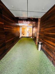 a room with a green floor with wooden walls at OYO Hotel Happy Homes in Bhopal