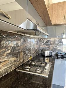 a kitchen with a stove with plastic wrap on it at Lovely 3 Bedrooms Fully Equipped With Central Ac in Rejiche