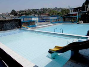 - une piscine avec un banc devant dans l'établissement Rumah Syariah Bugenvil, à Bandung