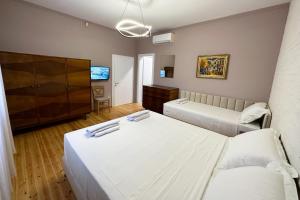 een hotelkamer met 2 bedden en een televisie bij Nicolaus Hidden Gem Villa in Shkodër