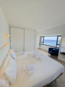 a bedroom with a large white bed with a large window at Apartamentos Arrecife Playa in Arrecife