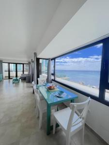 un comedor con mesa y sillas y el océano en Apartamentos Arrecife Playa, en Arrecife