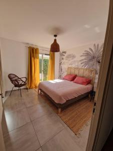 een slaapkamer met een bed en een stoel bij La Villa Bleue in Saumane-de-Vaucluse