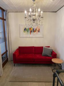 um sofá vermelho numa sala de estar com um lustre em Willkommen im Herzen Nürnbergs em Nurembergue