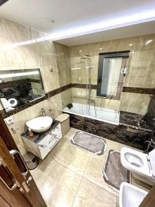 a bathroom with a sink and a tub and a toilet at Luxury 3 Bedrooms Apartment Sea View in Rejiche