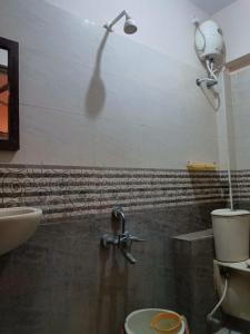 y baño con ducha, aseo y lavamanos. en Hotel Duwaraka, en Rameswaram